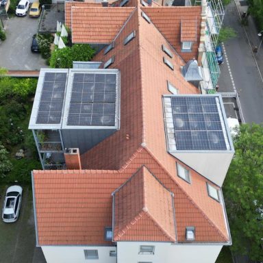 Photovoltaikanlage auf einem Mehrfamilienhaus mit rotem Ziegeldach in Konstanz.