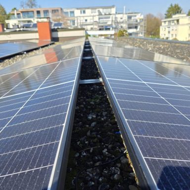 Photovoltaikmodule auf einem Flachdach Photovoltaikmodule auf einem Flachdach mit Blick auf umliegende Gebäude.