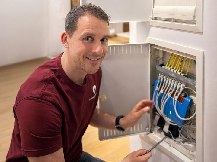 Elektriker von Breyer & Veron arbeitet an einem geöffneten Sicherungskasten in einem Wohngebäude in Konstanz.