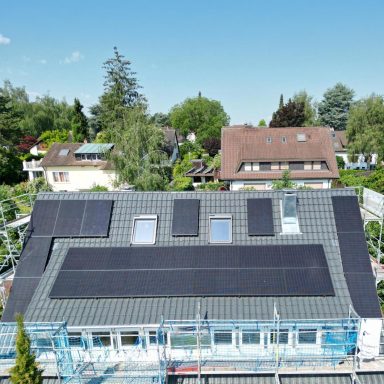 Photovoltaikanlage mit schwarzen Solarmodulen auf einem grauen Wohnhausdach in Konstanz.