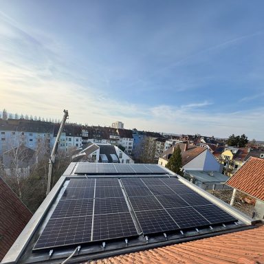 Photovoltaikanlage auf einem Hausdach in Konstanz Photovoltaikmodule auf einem geneigten Hausdach mit Blick über ein Wohngebiet.